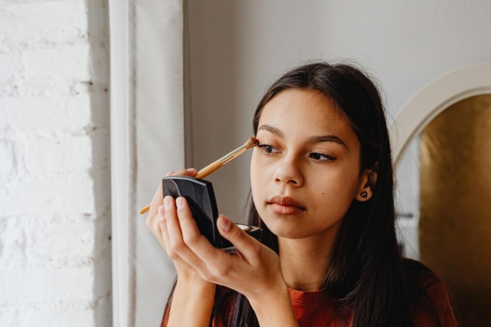 Mujer joven aplicando cosmético frente al espejo — rutinas de belleza y pre-juvenación Sostenica CDMX
