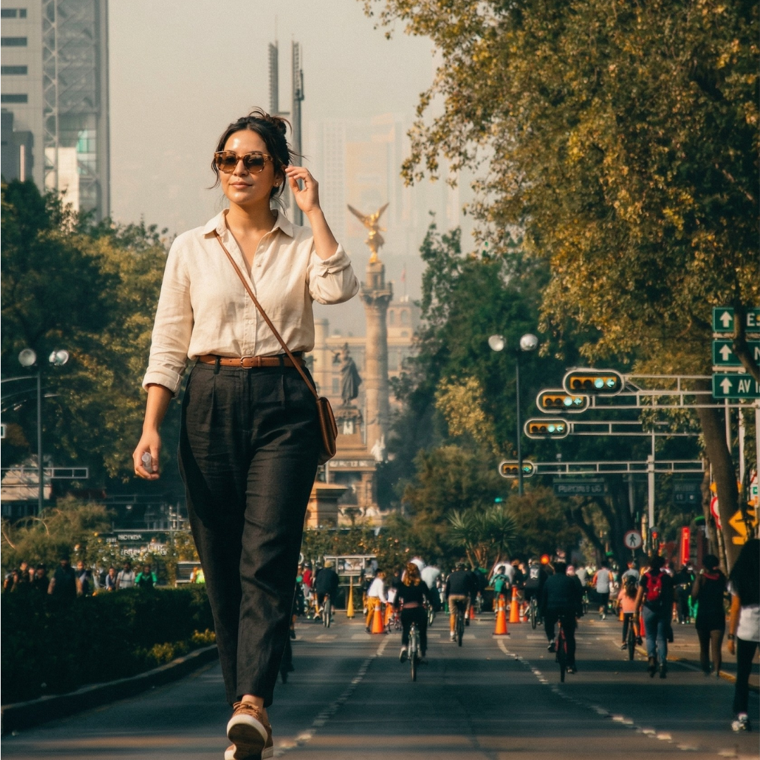 Mujer joven caminando con estilo cerca del Ángel de la Independencia en CDMX