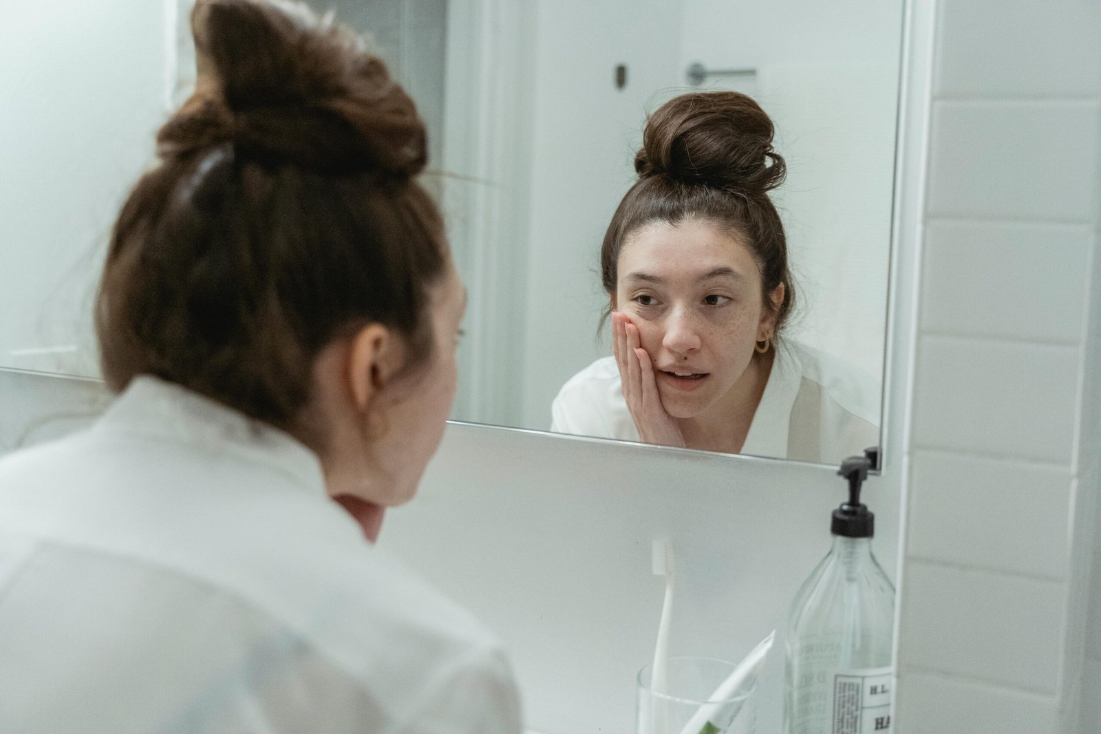 Woman analyzing sensitive skin in mirror